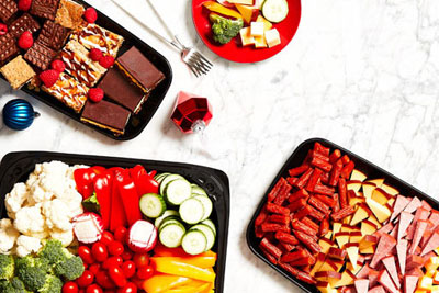 Charcuterie platter, veggie platter, and pastry tray arranged with a plate of cheese and freshly cut Vegetable