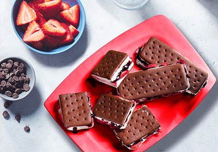 Red plate with stuffed ice cream sandwiches laid out on top