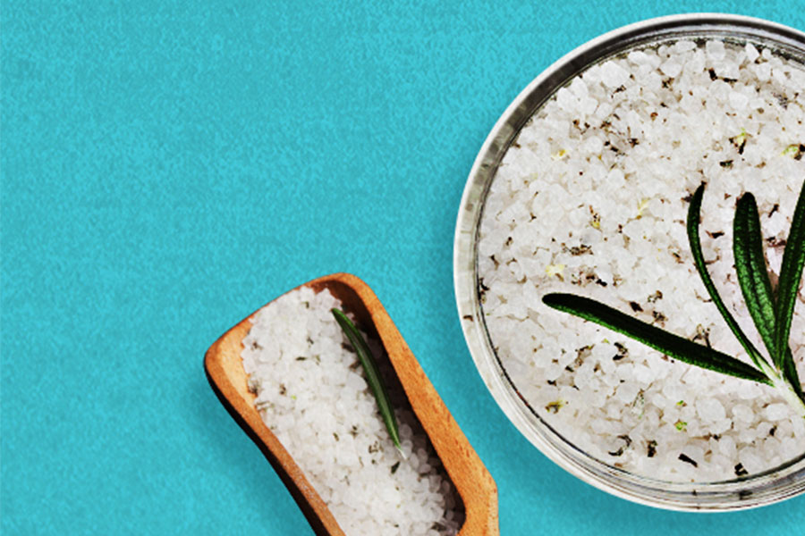 bowl of rosemary salt with small wooden scoop at the side