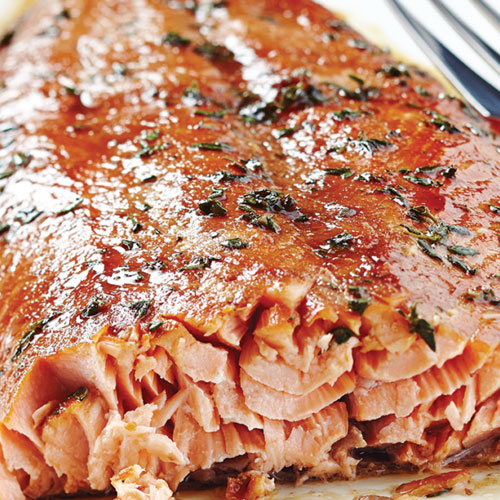 Close-up of an pomegranate glazed salmon filet on a cedar plank.