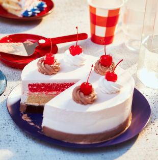 Neapolitan cake with a slice cut out, each on blue plates