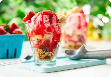 parfait glass of strawberry shortcake sundae with strawberry-flavoured syrup, granola and crumbled lemon cookies