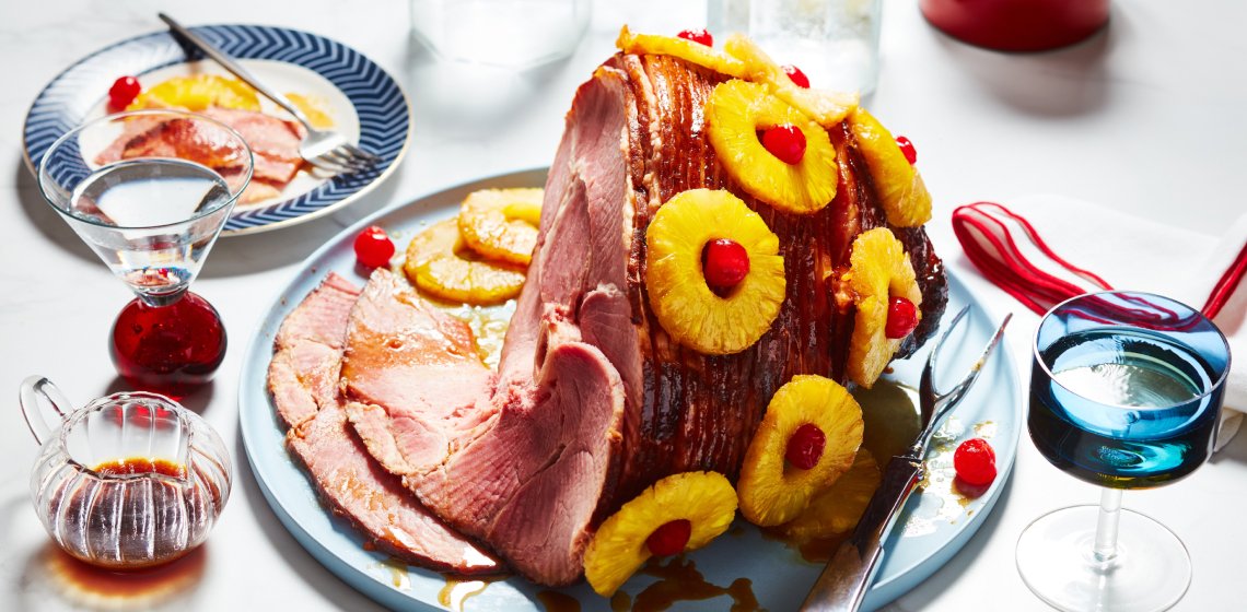 Light blue serving platter with Panache Spiral Sliced Ham studded with pineapple rings and red cherries.